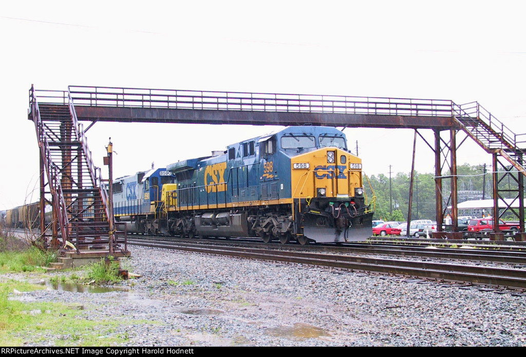 CSX 598 leads a southbound train parked under the pedestrian overpass (in a light rain)